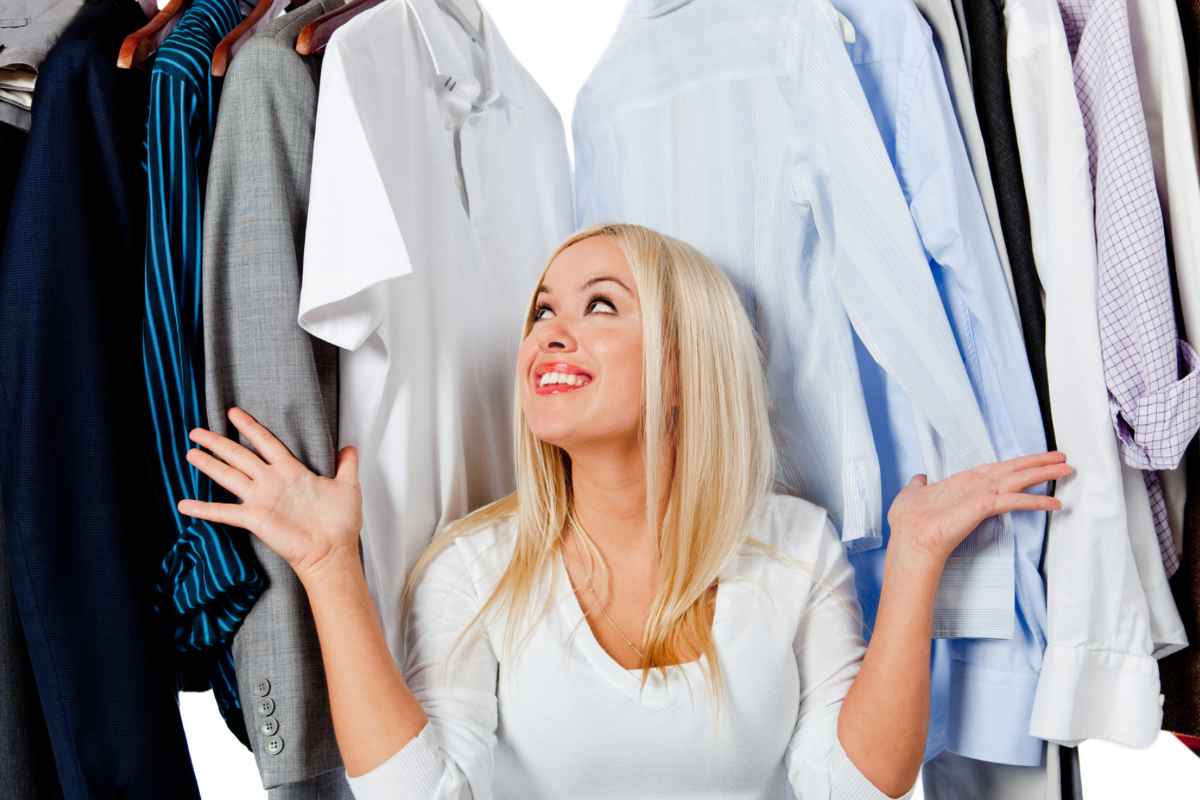 Donna che guarda i vestiti nell'armadio e sorride