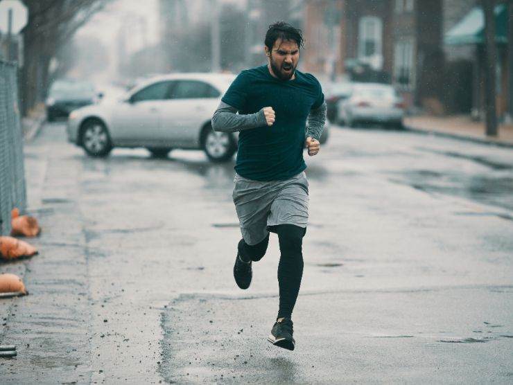 uomo che corre sotto la pioggia