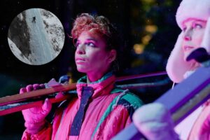 Due ragazze in tuta da sci e in evidenza una cascata di ghiaccio