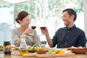 Una coppia asiatica brinda di fronte ad un tavolo imbandito