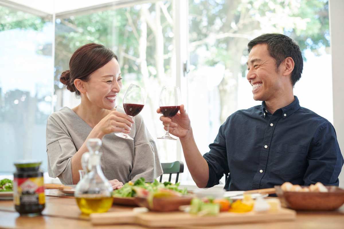 Una coppia asiatica brinda di fronte ad un tavolo imbandito